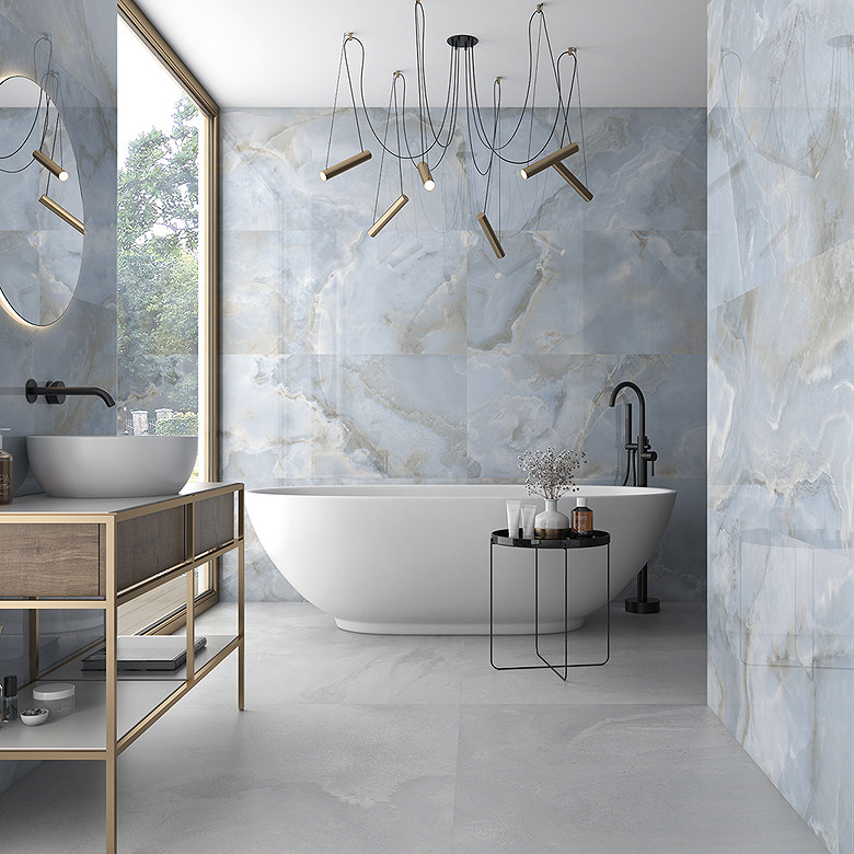 Large-format blue marble-effect bathroom wall tiles creating a luxurious backdrop around a freestanding bath