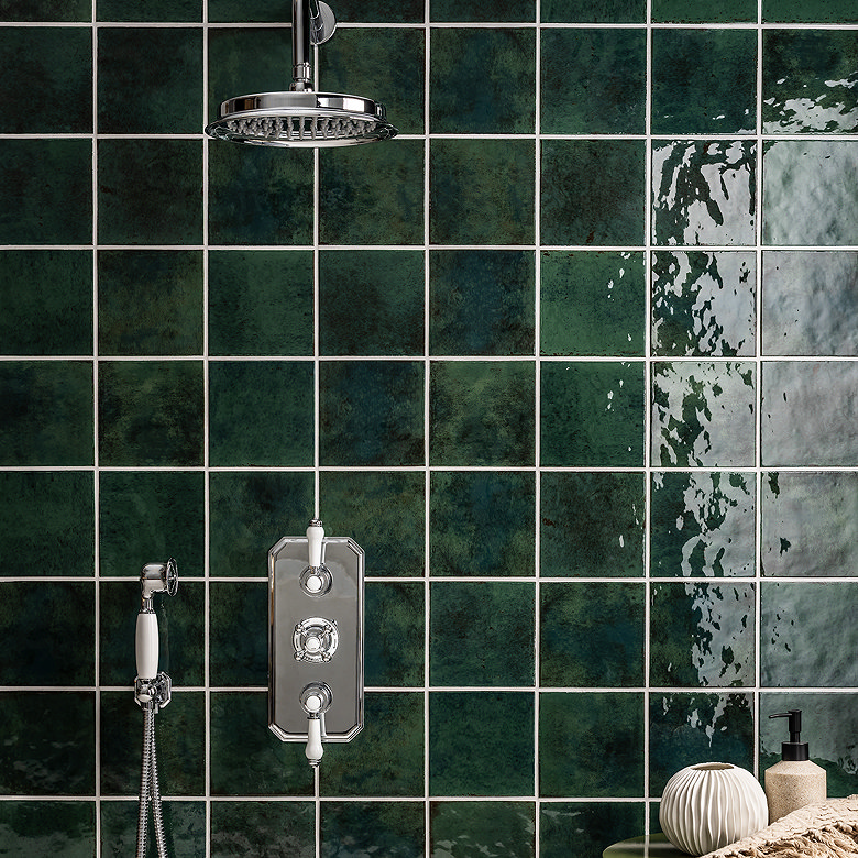 Glossy deep green square bathroom wall tiles creating a rich, colour-drenched backdrop for a traditional chrome shower