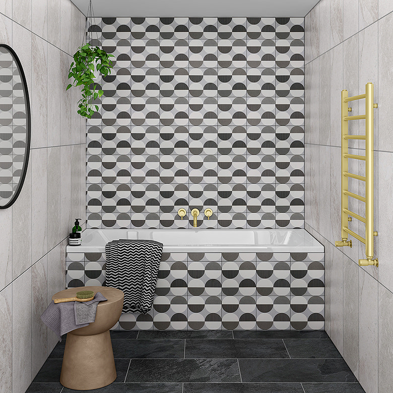 Black, white and grey geometric bathroom tiles used across the feature wall and bath panel for a coordinated look