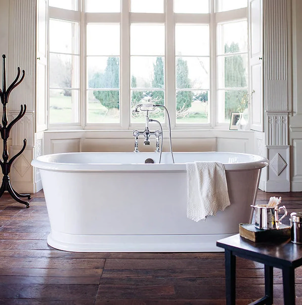 white double ended free standing bathtub, with wooden floor and big windows