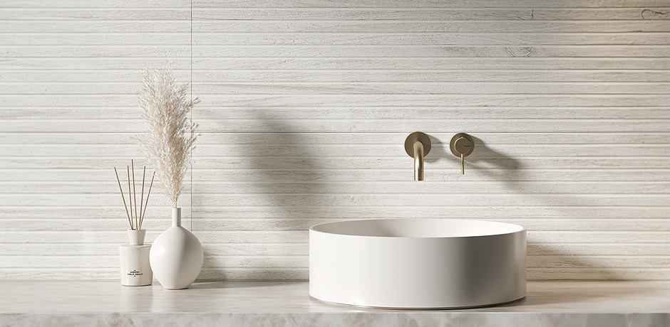 Round basin with brass tap and white tiles