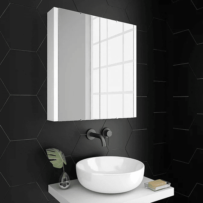 White mirrored cabinet on black tiled wall