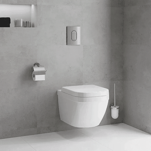Wall hung toilet on grey tiles with chrome flush plate