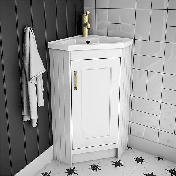 White corner vanity unit with brass handles and tap