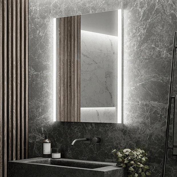 Illuminated mirror on grey marble wall with concrete basin and black tap