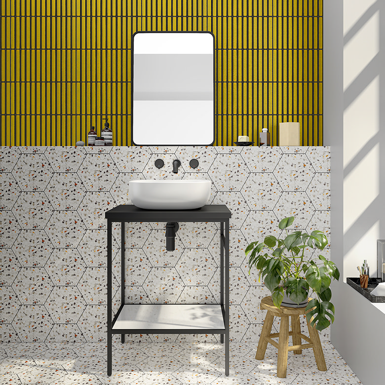 Modern bathroom with vibrant yellow vertical wall tiles paired with hexagonal terrazzo tiles, featuring a white basin and black fixtures, creating a bold, contemporary design.