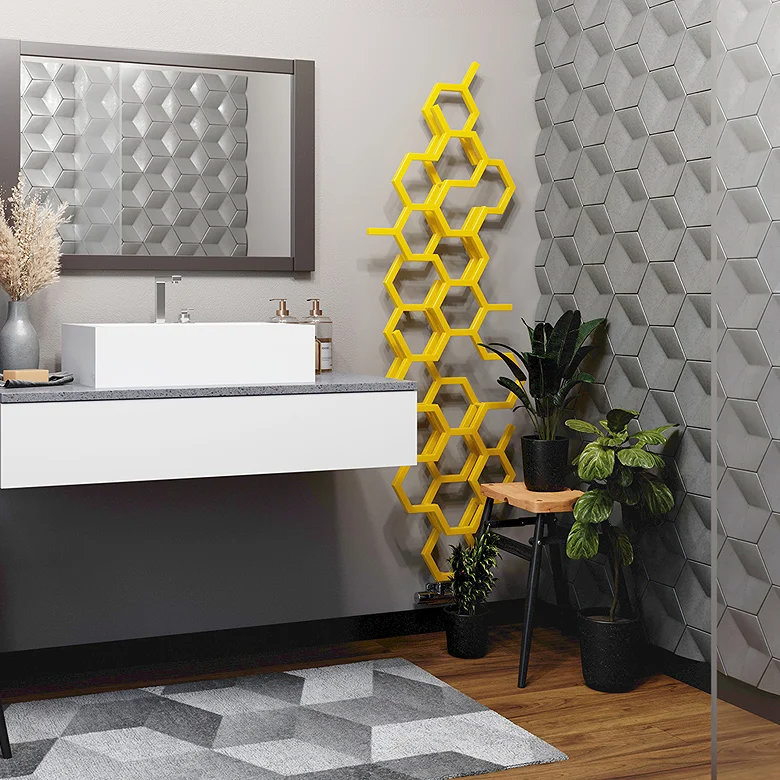 Hexagonal honeycomb-patterned yellow radiator mounted on a bathroom wall, adding a modern and vibrant accent to the space.