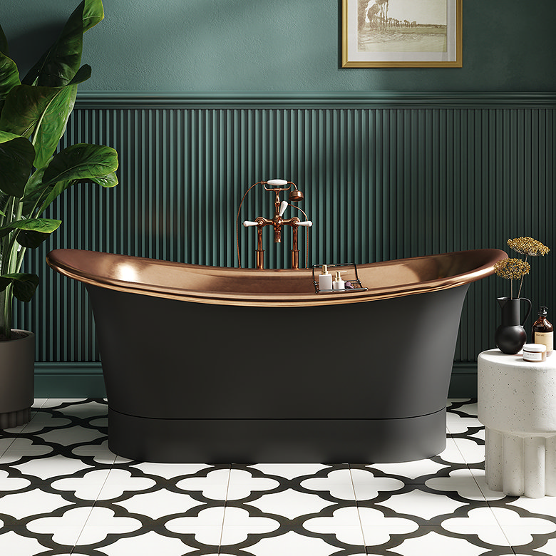 freestanding black and copper bath with traditional taps on patterned floor tiles in green bathroom