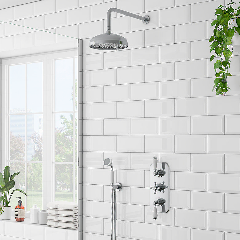 chrome thermostatic shower system with rainfall shower head and handheld shower on white subway tile wall