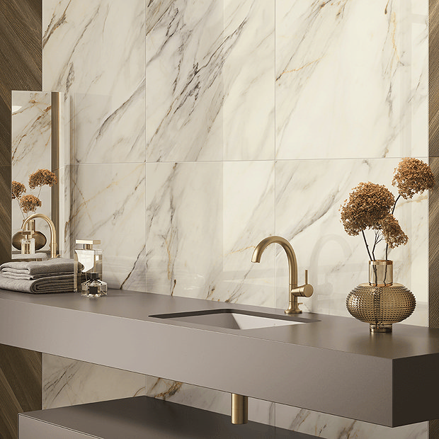 Marble wall tiles behind grey counter with brass tap