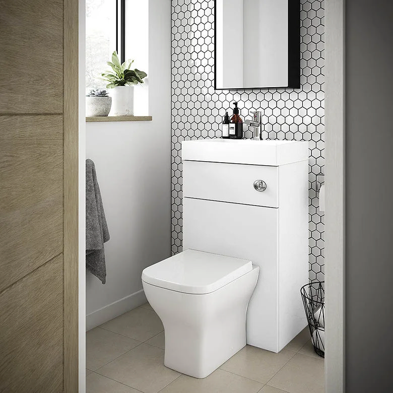 white toilet with small basin on top