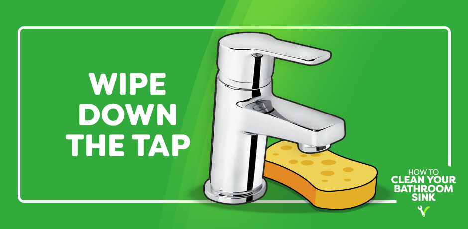 wiping down the tap while cleaning the bathroom sink