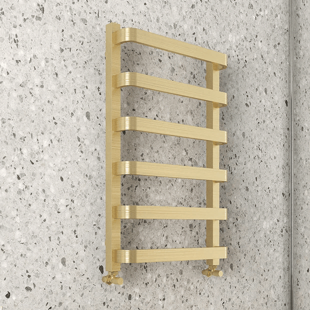 Brass modern towel rail on white terrazzo wall