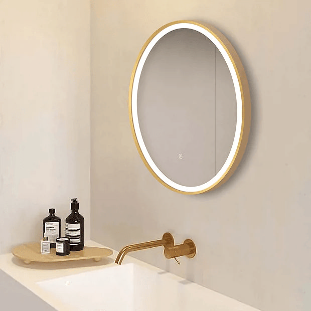Round illuminated brass mirror on beige wall