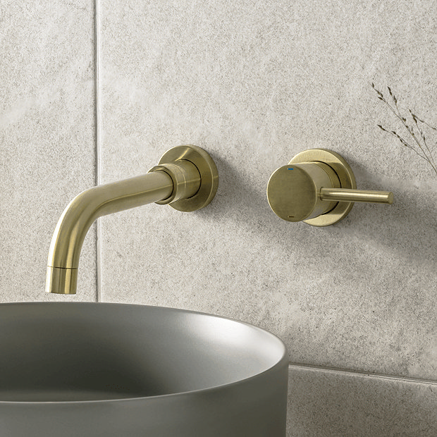 Brass wall mounted tap with grey basin and white tiles