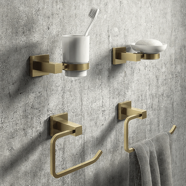 Gold bathroom accessories mounted on grey wall
