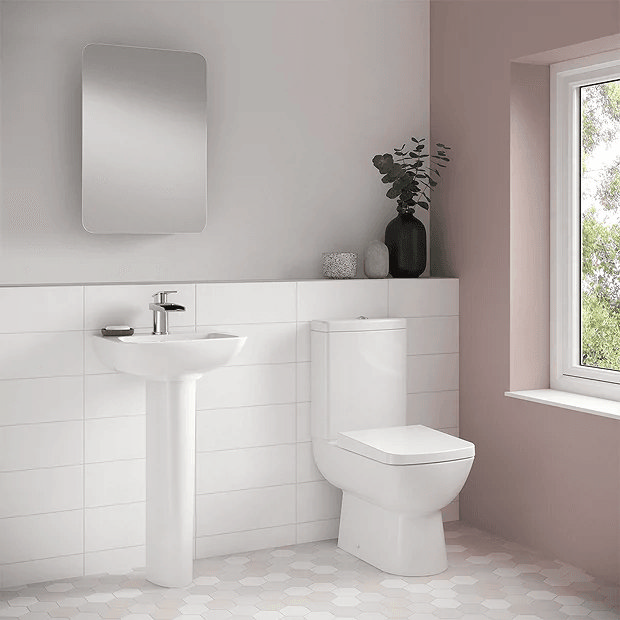 Compact toilet in pink and white bathroom