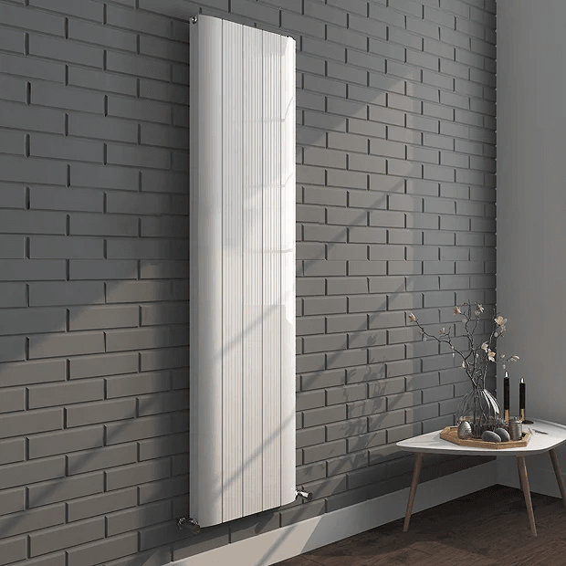 White radiator on grey brick wall