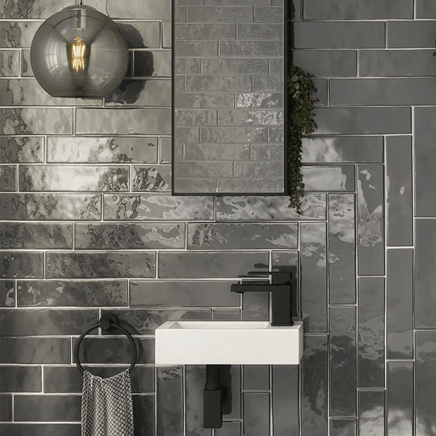 Dark grey brick tiles with modern wall mounted basin and black taps