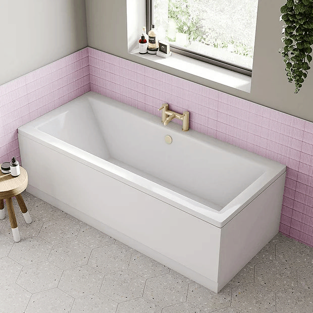 Pink wall tiles behind bath