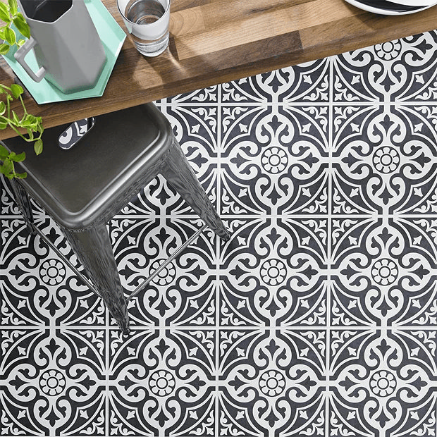 Black and white patterned tiles under a stool 