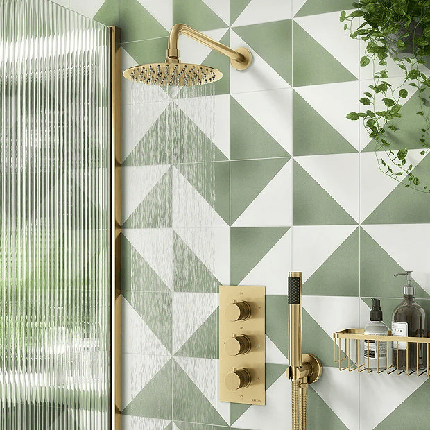 Brass shower with green and white tiles and fluted shower screen