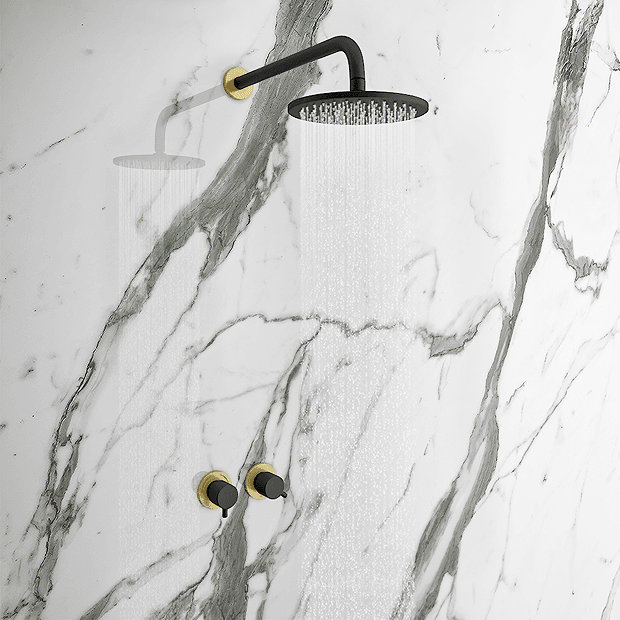 Black and brass rainfall shower on marble wall