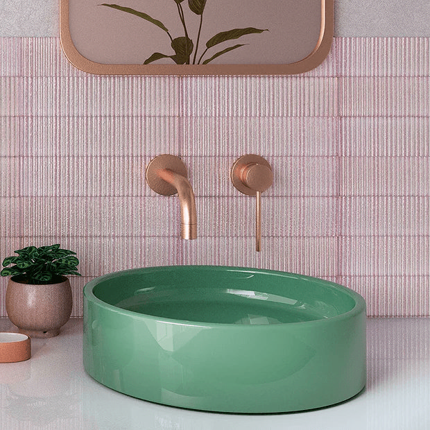 Pink tiles and green basin with copper taps