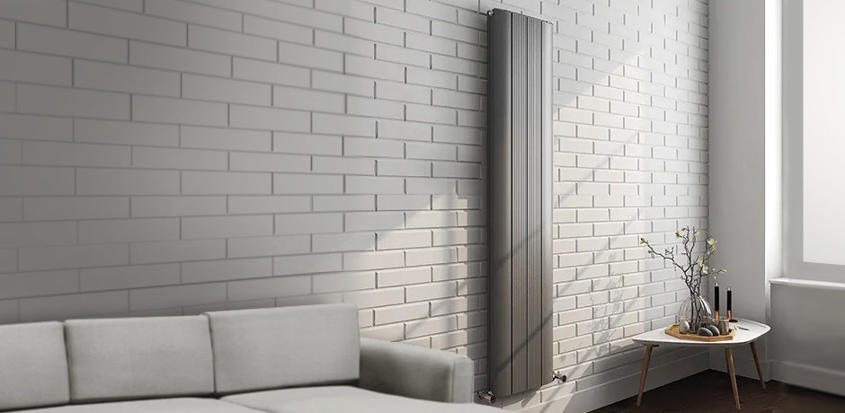 Grey slim radiator on white brick wall
