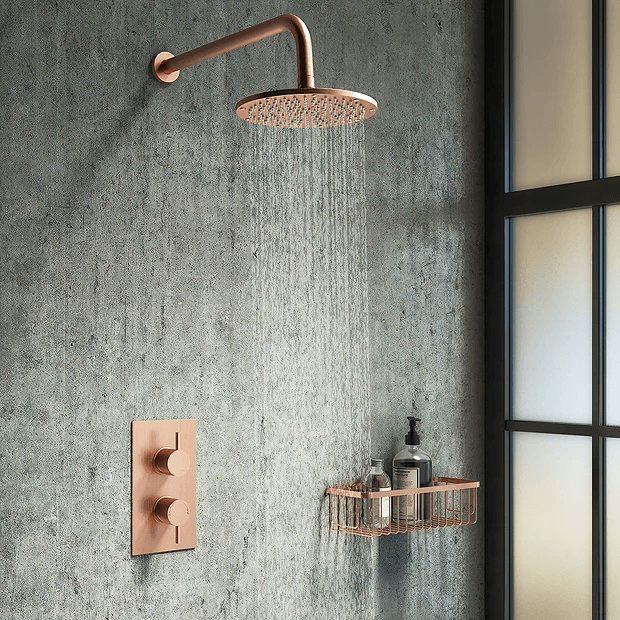 Rose gold shower on grey stone wall