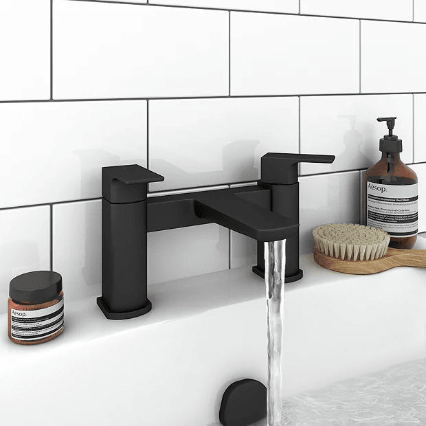 Black bath filler against white tiles