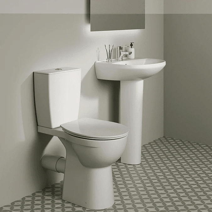 Compact toilet and pedestal basin on green and white tiles