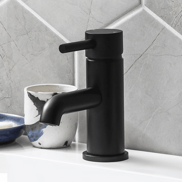 Modern black basin tap with grey wall