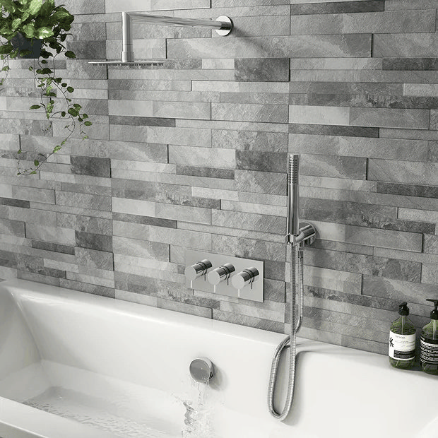Chrome wall mounted rainfall showerhead over bathtub with grey tiles