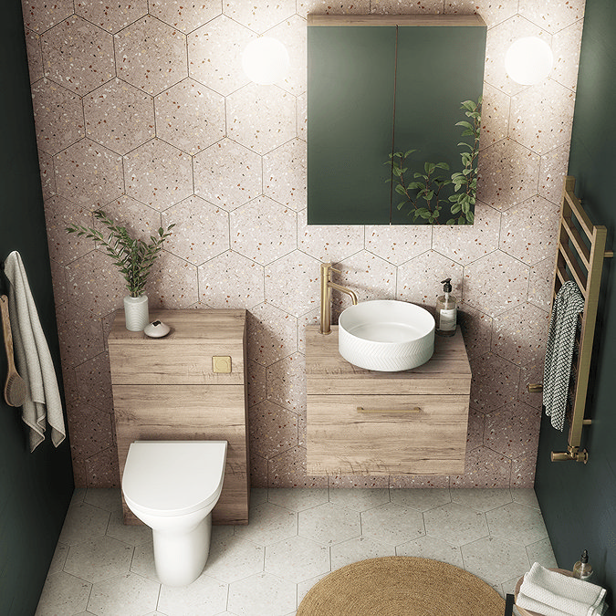 Oak effect furniture with pink wall tiles