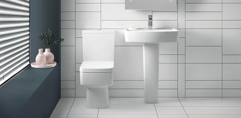 Modern toilet and pedestal basin on white tiles with blue window sill