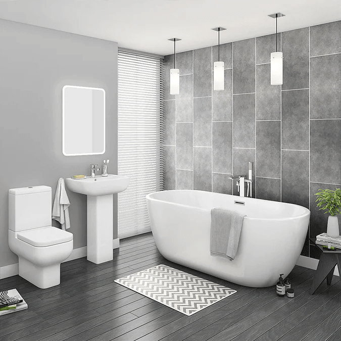 Modern bathroom with freestanding bath and grey tiles and hanging pendant light 