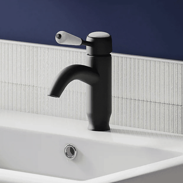 Traditional black basin tap against blue wall