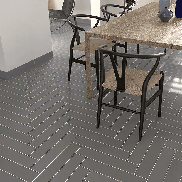 Grey herringbone floor tiles in a dining room