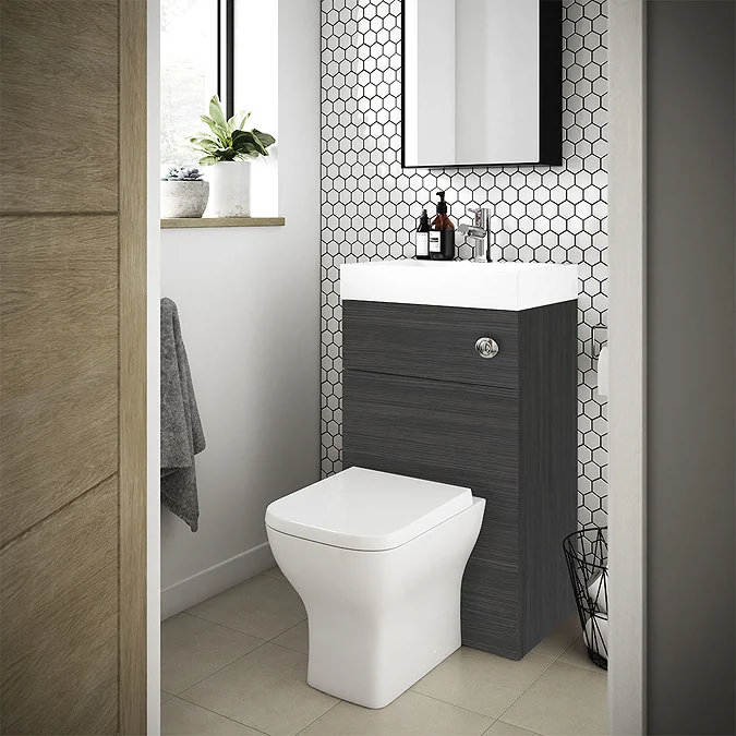 Black toilet basin combination unit in small cloakroom