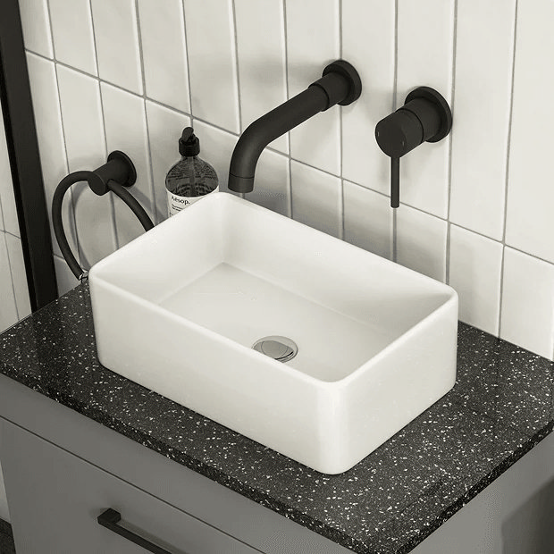 Rectangular basin with black taps