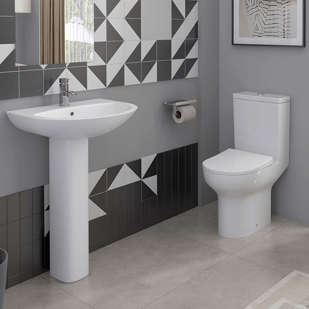 Space saving toilet in small bathroom with black and white tiles