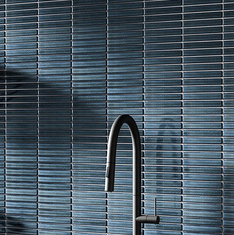 Dark blue tiles behind black tap