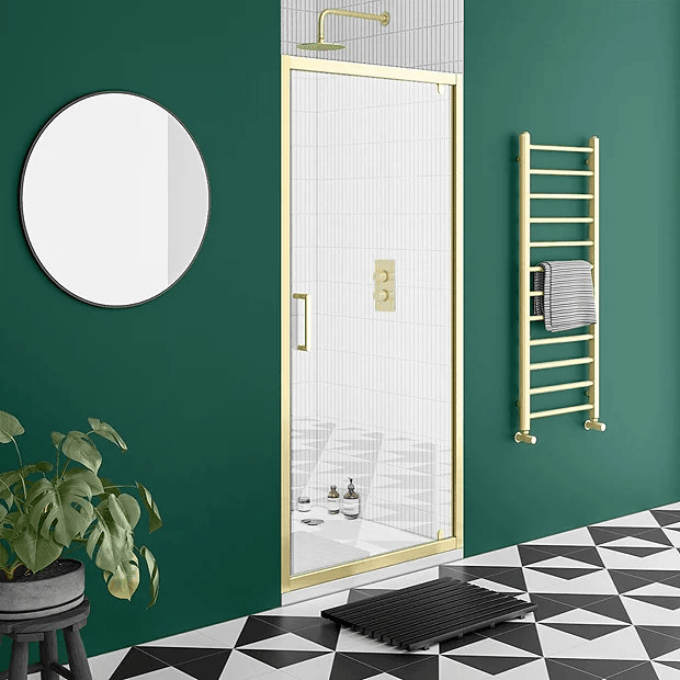 Brass shower door in green bathroom
