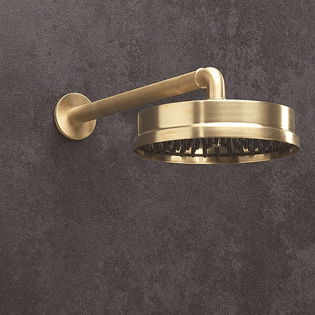 Traditional brass shower head on grey wall