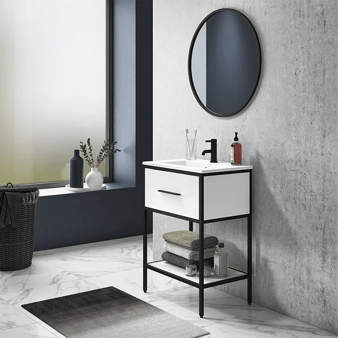 black and white vanity unit against concrete wall with black tap and round mirror