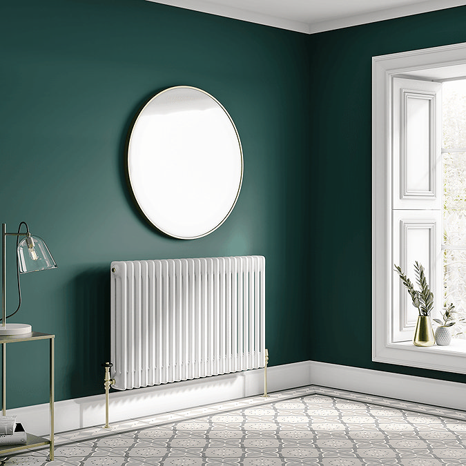 White column radiator against green wall