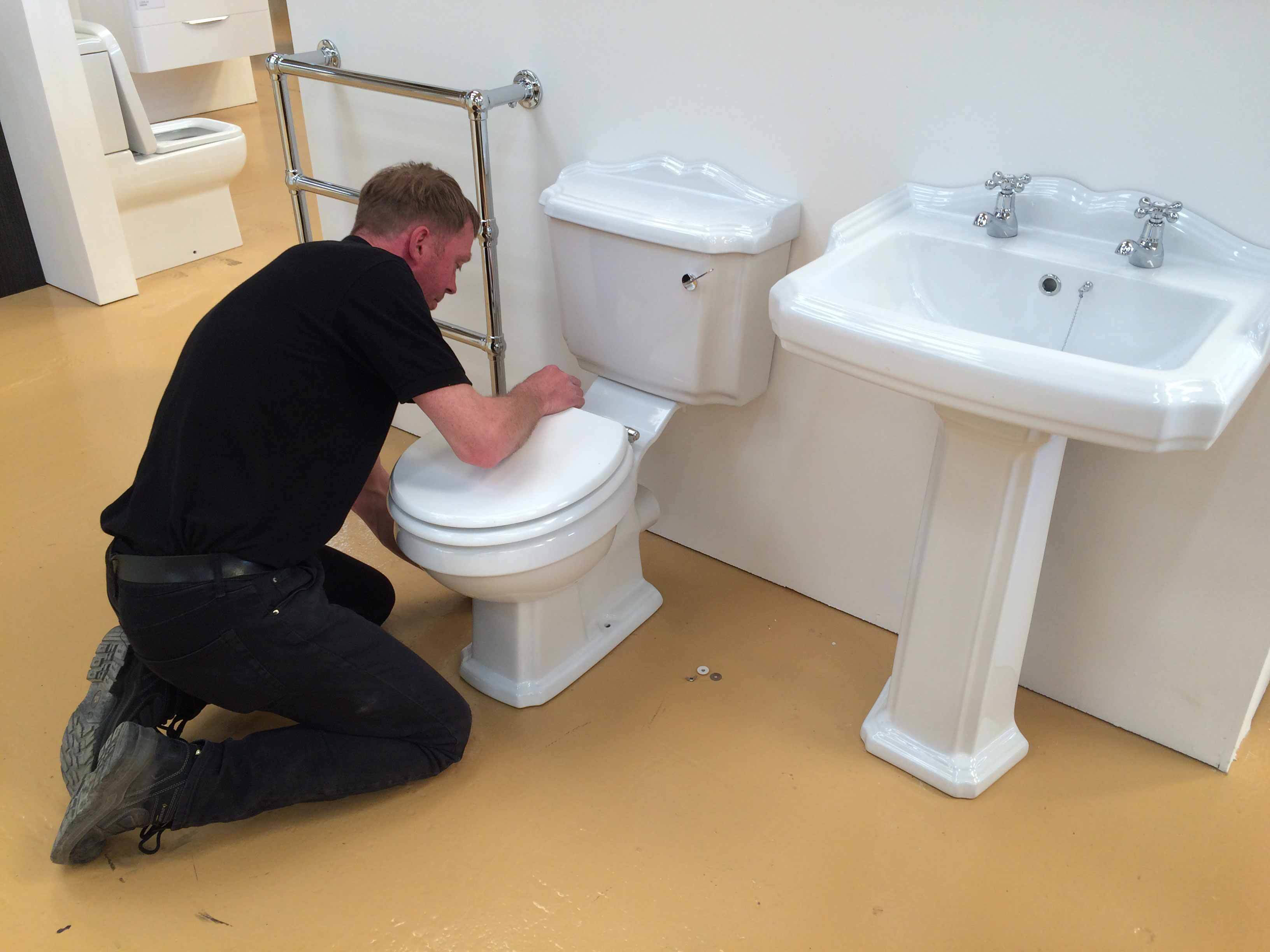 man replacing toilet seat