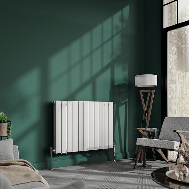 White panel radiator on dark green wall with floor lap and large window