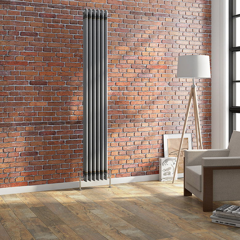 Tall anthracite vertical column radiator mounted on an exposed brick wall in a modern living room